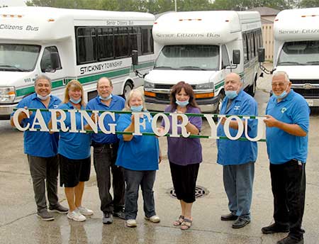 Highway Department drivers hold Caring For You sign