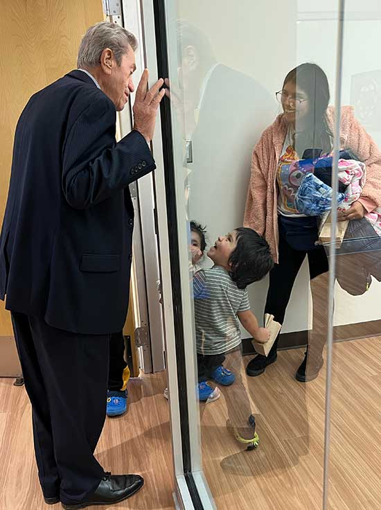 Supervisor Viverito and a young reader at the door to the Children's Room